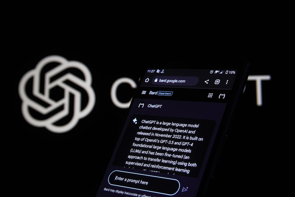 a close up of a cell phone with a logo in the background